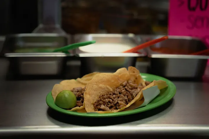 Orden de tacos servida en el mostrador de una taquería